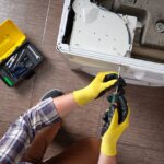 Close-up,Of,A,Household,Appliance,Repairman,Disassembling,A,Washing,Machine