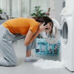 Worried,Woman,Calling,A,Repairman,,The,Washing,Machine,Is,Broken