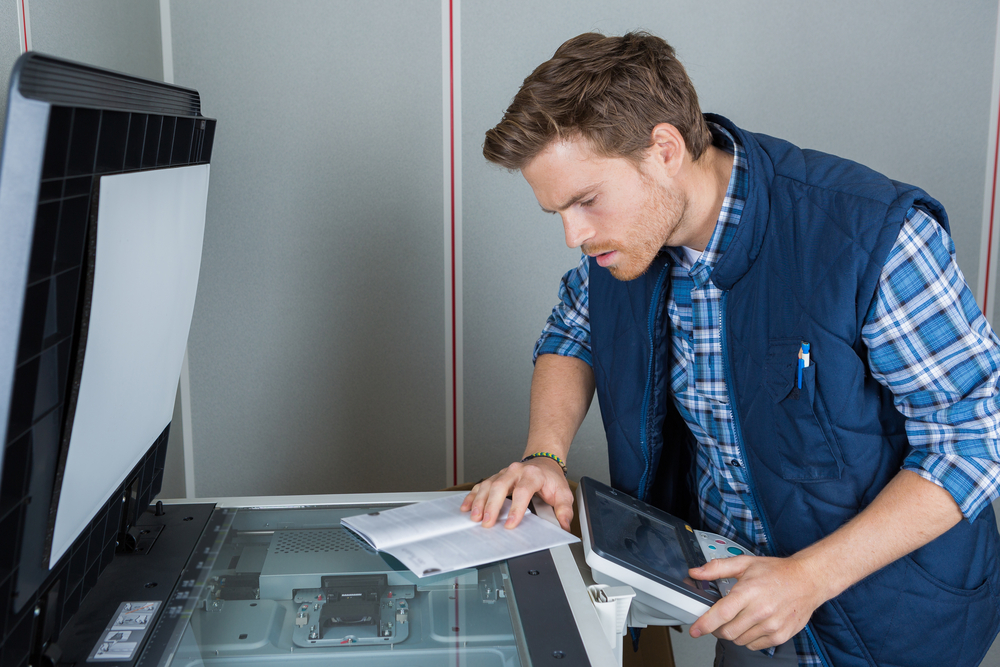 Man,Reading,Instructions,To,Repair,Photocopier