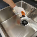 A,Human,Hand,Holds,The,Sewer,Lid,Of,A,Kitchen