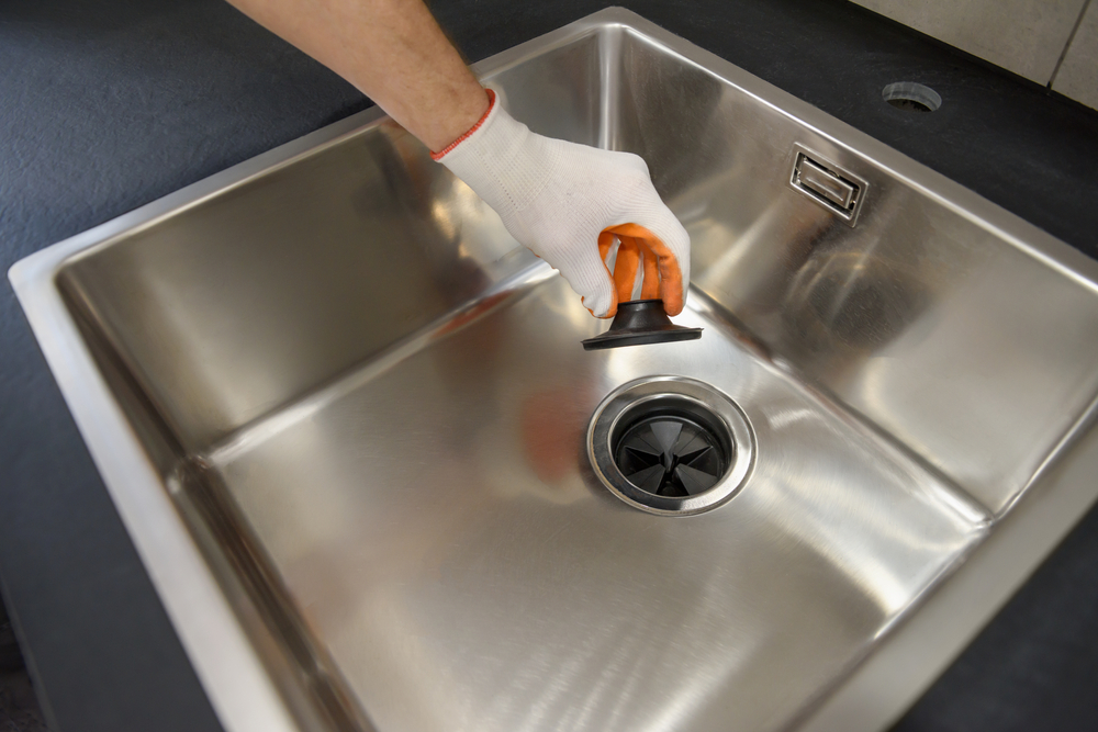 A,Human,Hand,Holds,The,Sewer,Lid,Of,A,Kitchen