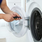 Young,Handyman,Fixing,Washing,Machine,,Closeup.,Laundry,Day